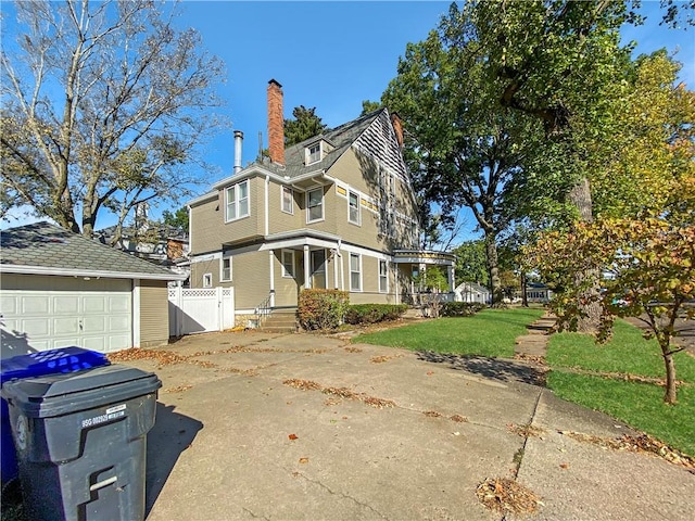 view of side of home with a yard, an outdoor structure, and a garage