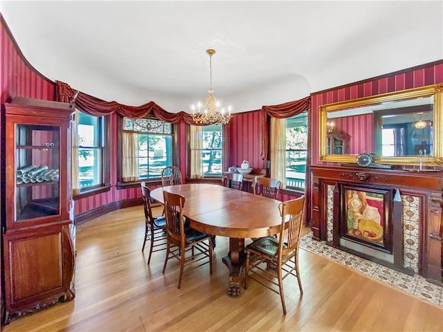 dining space featuring a wealth of natural light, light hardwood / wood-style flooring, and an inviting chandelier