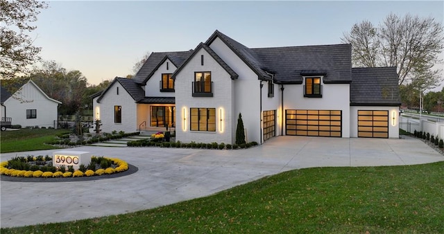 modern farmhouse with a yard and a garage