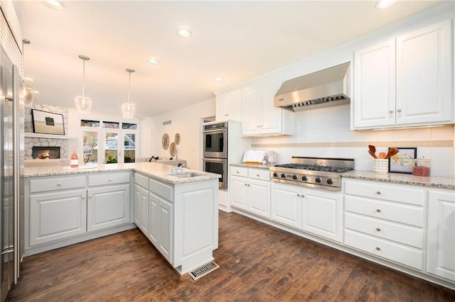 kitchen with white cabinetry, stainless steel appliances, hanging light fixtures, kitchen peninsula, and exhaust hood