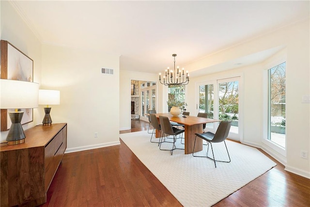 dining area featuring dark hardwood / wood-style floors, an inviting chandelier, and ornamental molding