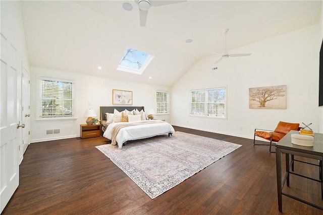 bedroom with vaulted ceiling with skylight, ceiling fan, and dark hardwood / wood-style floors