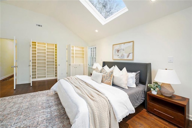 bedroom with dark hardwood / wood-style floors and lofted ceiling with skylight