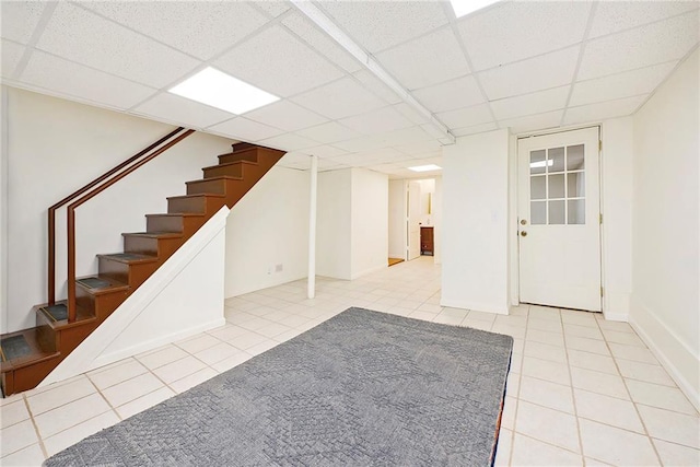 interior space with a paneled ceiling and light tile patterned floors