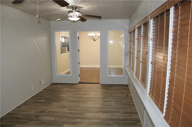 unfurnished room with ceiling fan with notable chandelier and dark hardwood / wood-style floors