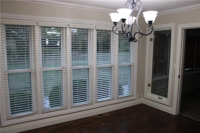 unfurnished dining area with crown molding, dark hardwood / wood-style flooring, and a chandelier