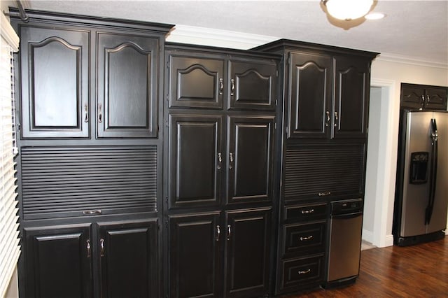 kitchen with dark wood-type flooring, stainless steel fridge, and crown molding