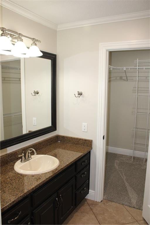 bathroom featuring tile patterned flooring, crown molding, and vanity