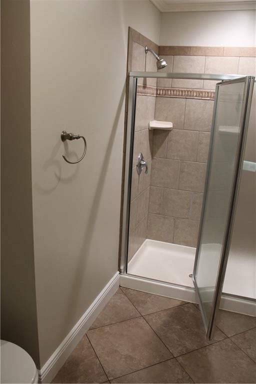 bathroom featuring tile patterned flooring, a shower with shower door, and toilet