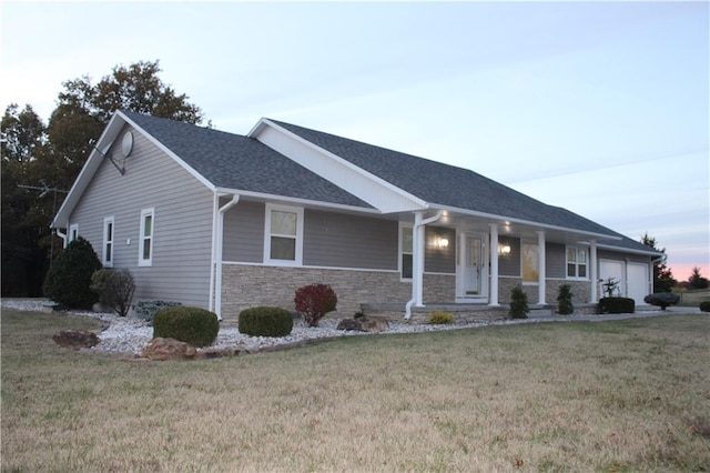 view of front of house with a porch, a garage, and a lawn