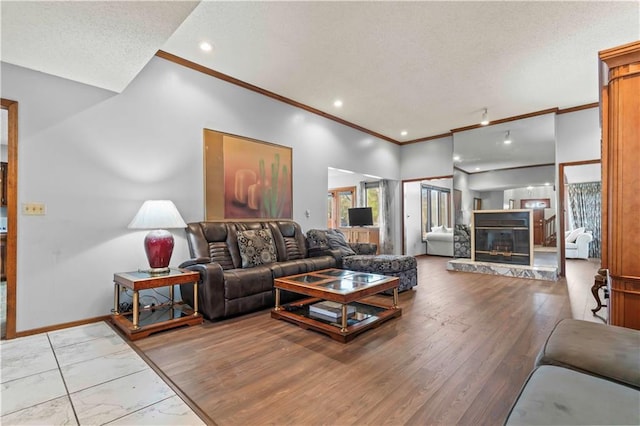 living room featuring light hardwood / wood-style flooring, a textured ceiling, and ornamental molding