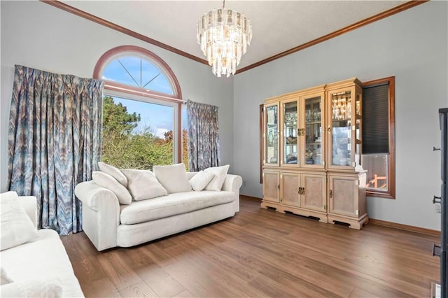 living room with crown molding, dark wood-type flooring, and a notable chandelier