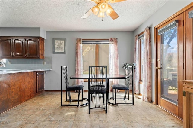 dining area with ceiling fan and a textured ceiling