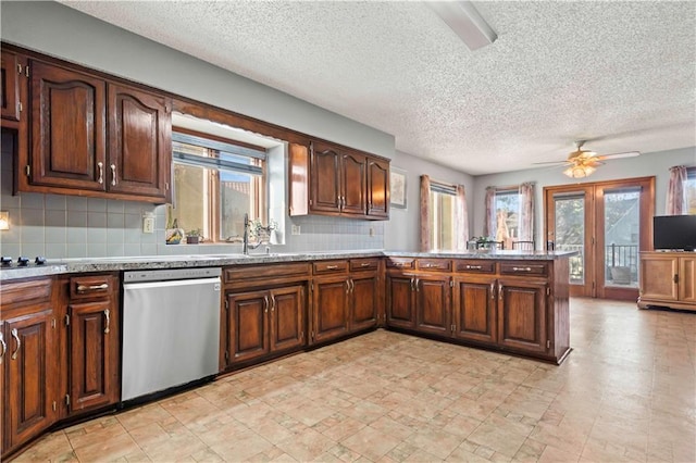 kitchen featuring ceiling fan, french doors, stainless steel dishwasher, backsplash, and kitchen peninsula