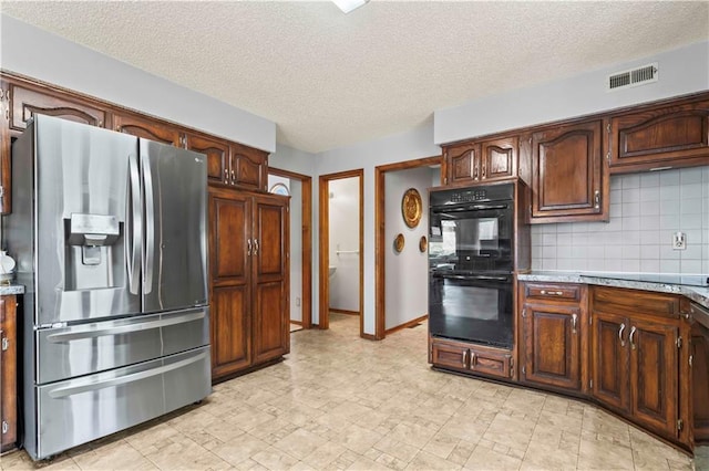 kitchen with a textured ceiling, backsplash, and black appliances