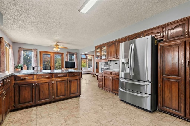 kitchen with ceiling fan, french doors, stainless steel refrigerator with ice dispenser, a textured ceiling, and decorative backsplash