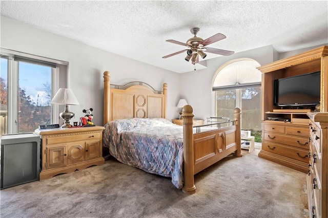 bedroom featuring carpet flooring, a textured ceiling, and ceiling fan