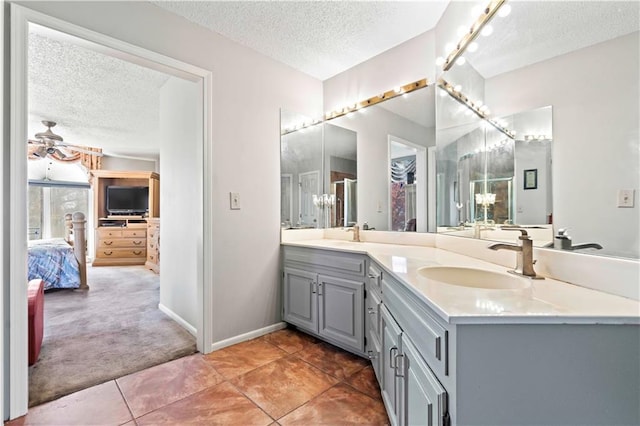 bathroom featuring tile patterned flooring, vanity, and a textured ceiling