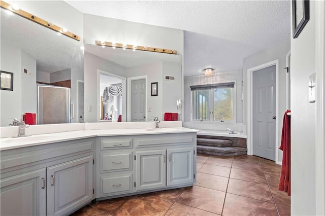 bathroom with tile patterned flooring, vanity, a textured ceiling, and independent shower and bath