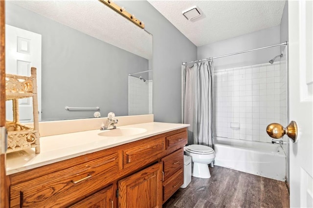 full bathroom with hardwood / wood-style flooring, vanity, toilet, and a textured ceiling