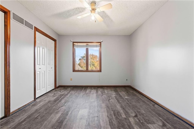 unfurnished bedroom featuring a textured ceiling, dark hardwood / wood-style flooring, a closet, and ceiling fan