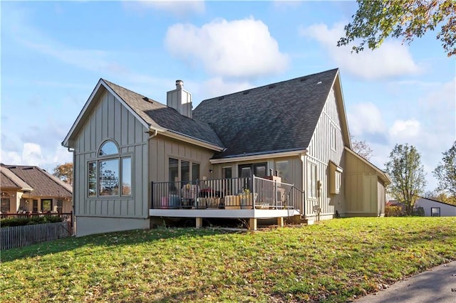 back of property featuring a lawn and a wooden deck