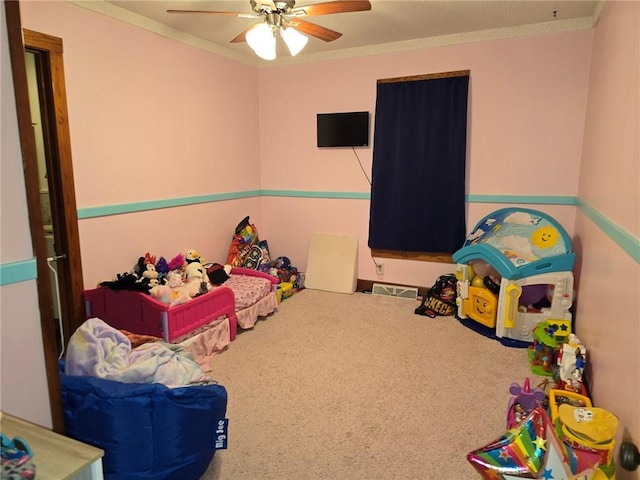 rec room with carpet, ceiling fan, and ornamental molding