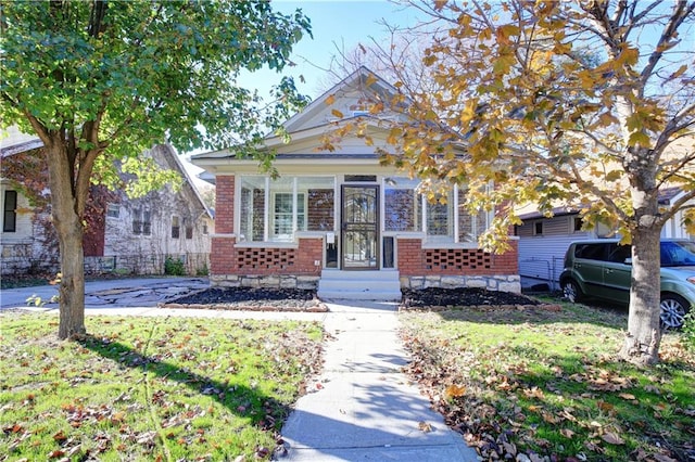 view of front of property featuring a sunroom and a front lawn