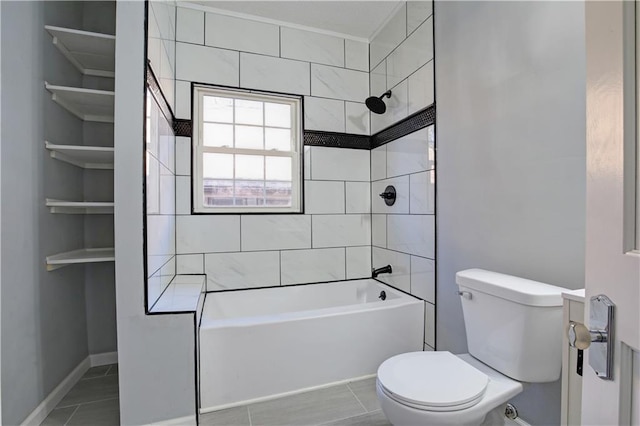 bathroom featuring tile patterned floors, toilet, and tiled shower / bath