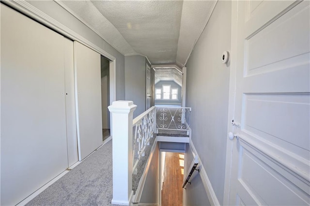 hallway featuring carpet floors and a textured ceiling