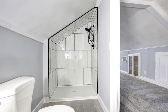 bathroom with a shower, lofted ceiling, and toilet