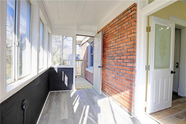 unfurnished sunroom with a healthy amount of sunlight and vaulted ceiling