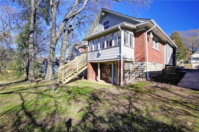 view of side of home with central air condition unit and a lawn