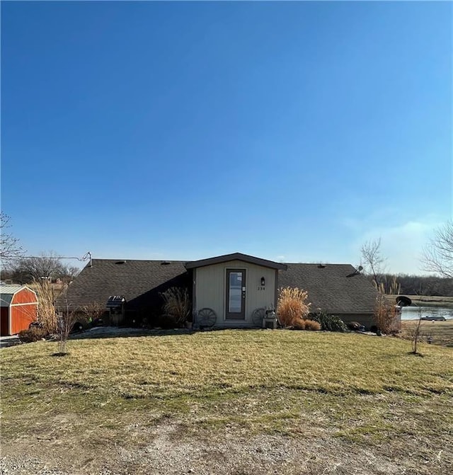 view of front of property with a front lawn and a shed