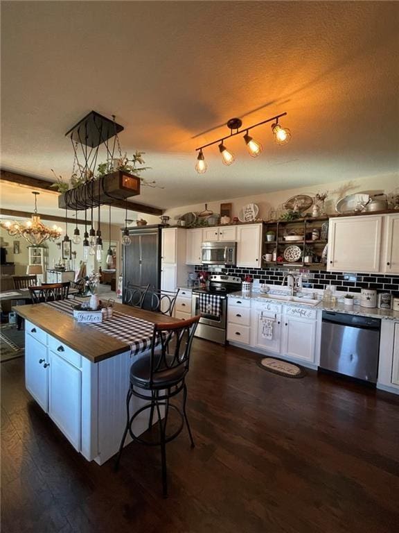 kitchen featuring white cabinets, dark hardwood / wood-style flooring, stainless steel appliances, and sink