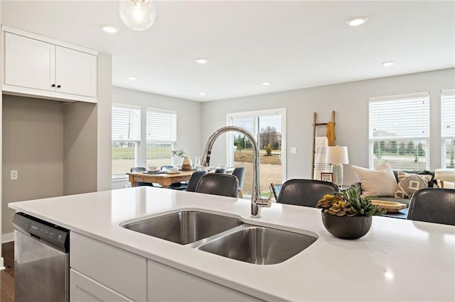 kitchen with hardwood / wood-style flooring, dishwasher, white cabinetry, and sink