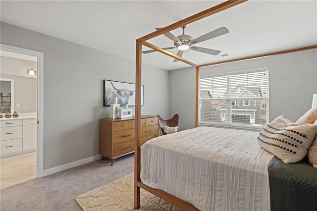 bedroom featuring connected bathroom, light carpet, and ceiling fan