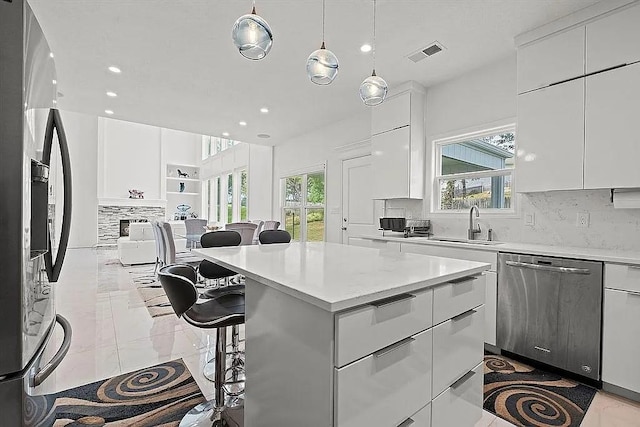 kitchen with a wealth of natural light, white cabinets, and stainless steel appliances