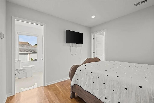 bedroom featuring ensuite bath and light hardwood / wood-style flooring