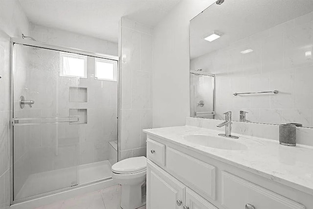 bathroom with vanity, toilet, and a shower with door