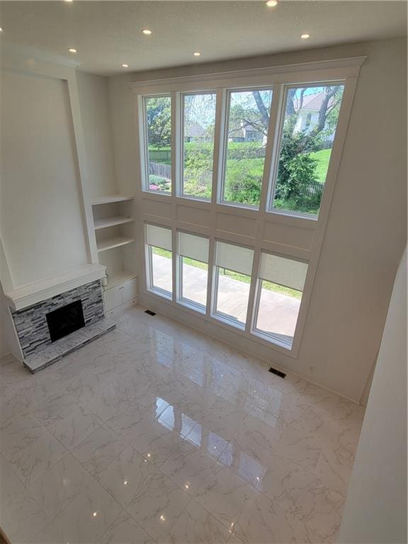 17012 E 38th Ter S, Independence, MO 64055 - unfurnished living room with plenty of natural light, recessed lighting, built in features, a fireplace, and marble finish floors