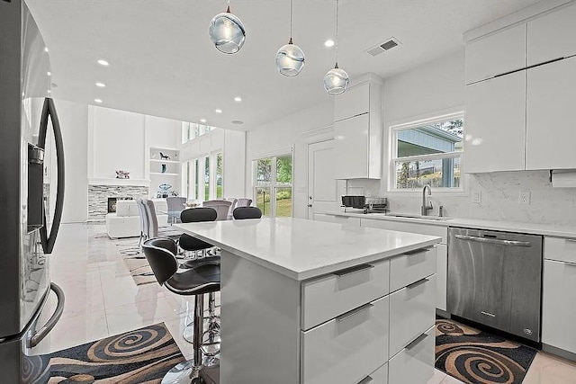 17012 E 38th Ter S, Independence, MO 64055 - kitchen featuring appliances with stainless steel finishes, a kitchen bar, recessed lighting, modern cabinets, and light countertops