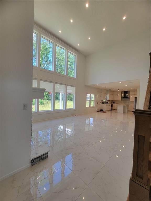 17012 E 38th Ter S, Independence, MO 64055 - unfurnished living room with a high ceiling, light marble finish floors, and recessed lighting