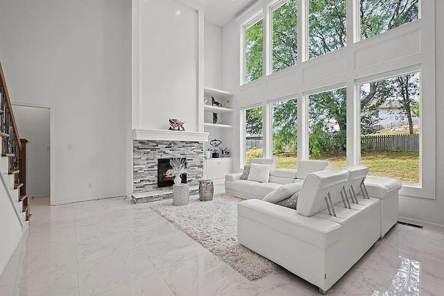 17012 E 38th Ter S, Independence, MO 64055 - living area with a towering ceiling, marble finish floors, stairs, a fireplace, and built in shelves