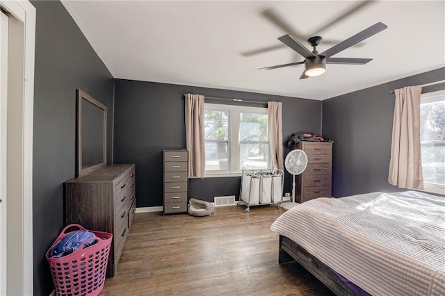 bedroom with ceiling fan, wood-type flooring, and multiple windows