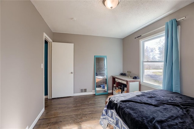 bedroom featuring a textured ceiling and dark wood-type flooring