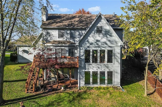 rear view of property featuring a lawn, a wooden deck, and fence