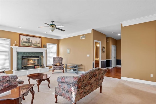 living room with crown molding, light colored carpet, visible vents, a tile fireplace, and baseboards