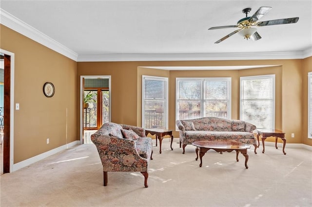 carpeted living room with ceiling fan and crown molding