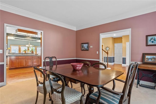 dining area with ornamental molding, stairway, and a notable chandelier